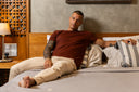 Man sitting on a bed in a bedroom setting